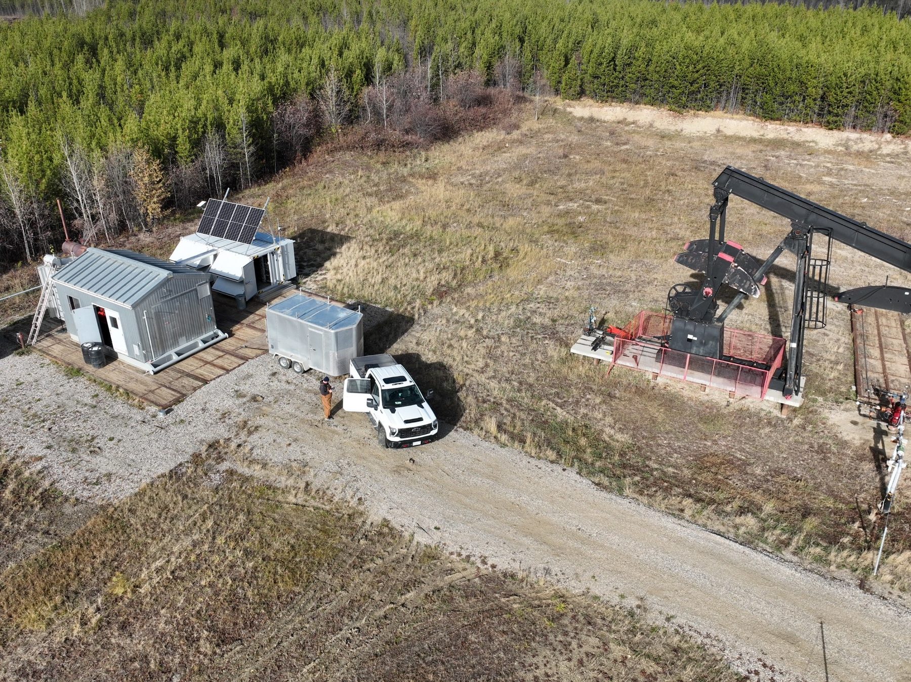 Aerial view of containerised equipment next to a producing pump jack.