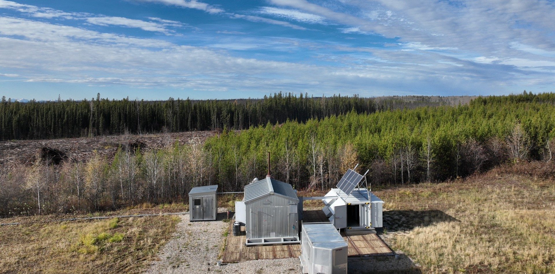 Aerial view of a remote generation and mining site surrounded by forest.