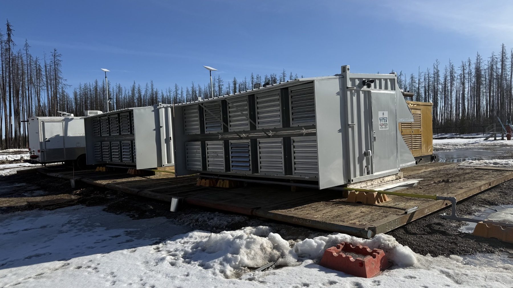 Containerised mining units on a cold-weather pad.