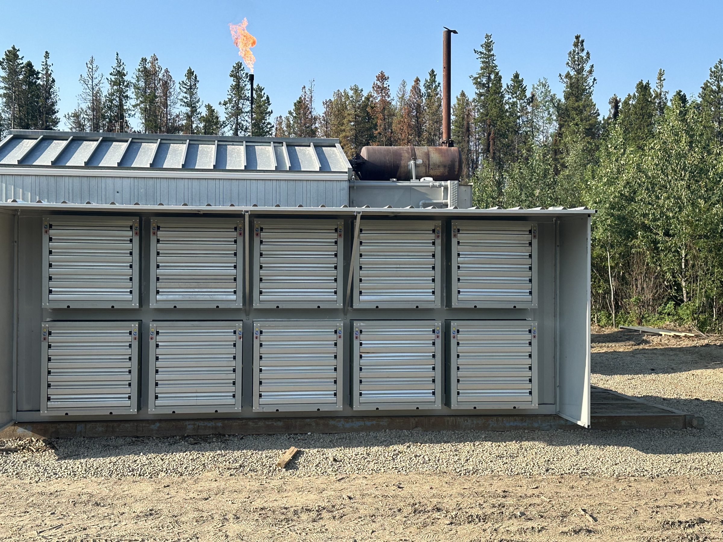Mining container on pad with flare stack in the background.