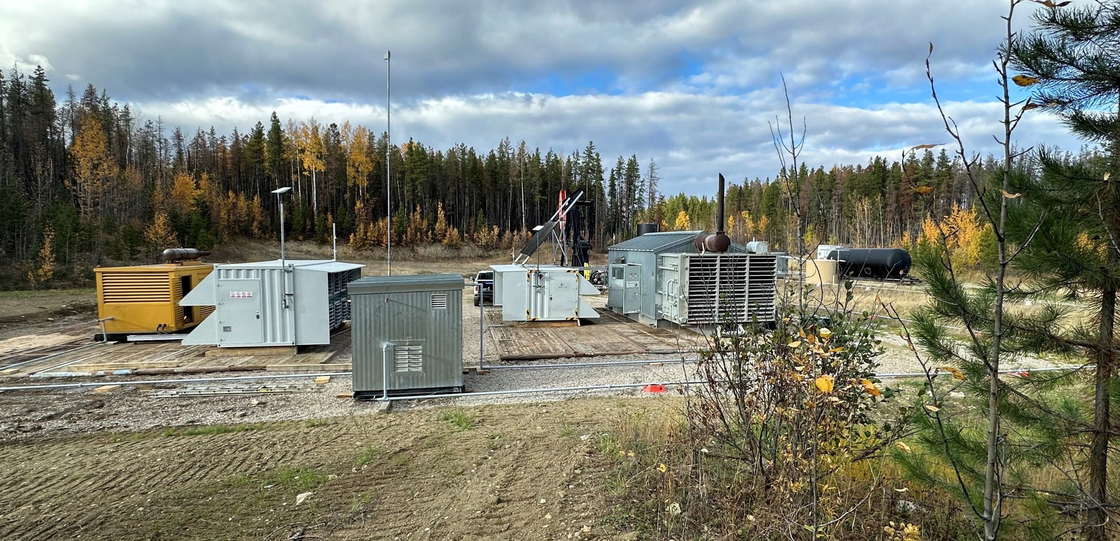 Wide view of a complete site with generators, containers, and flare.
